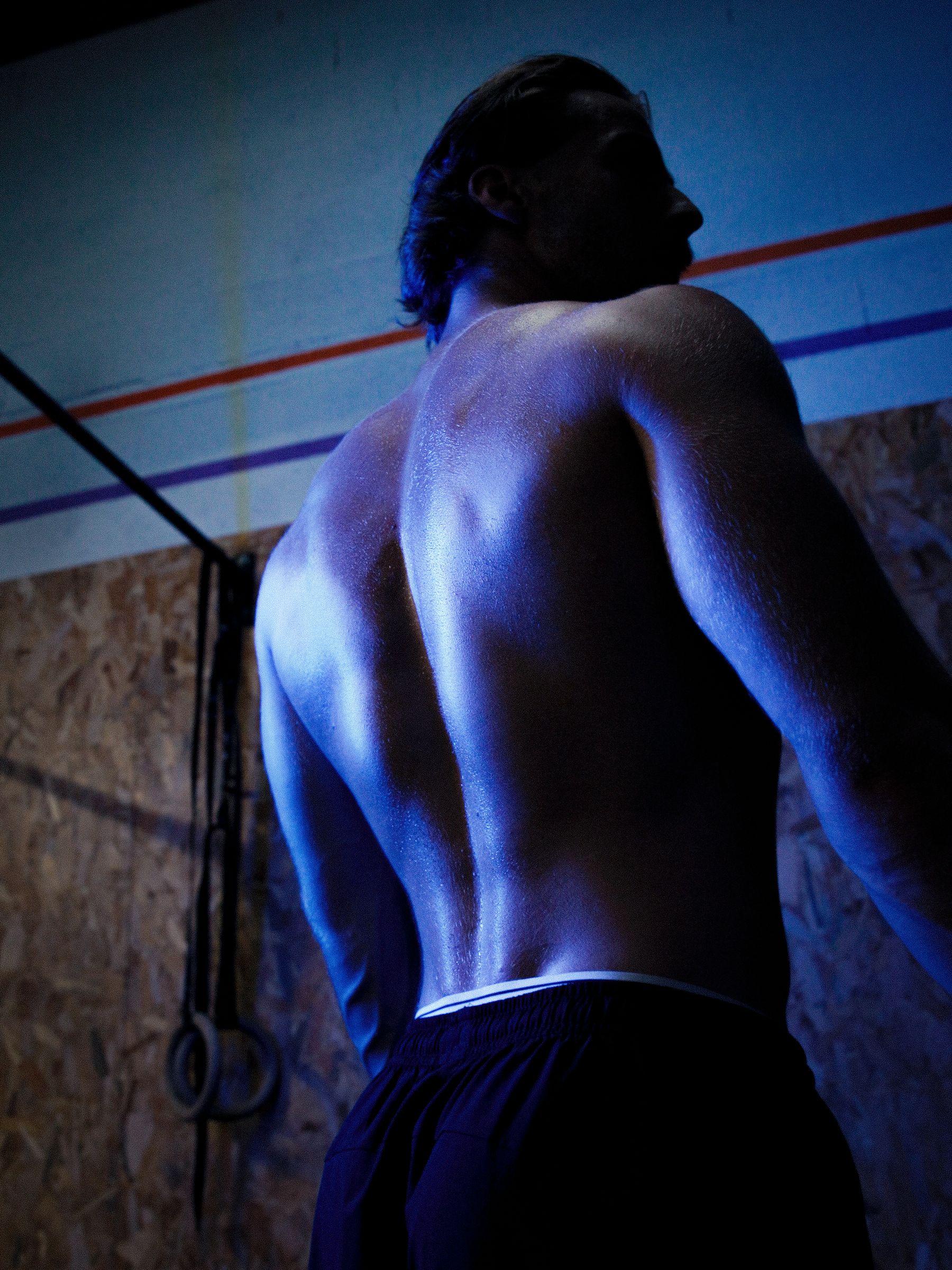 Guillaume, coach Punch, torse nu de dos en salle d’entraînement